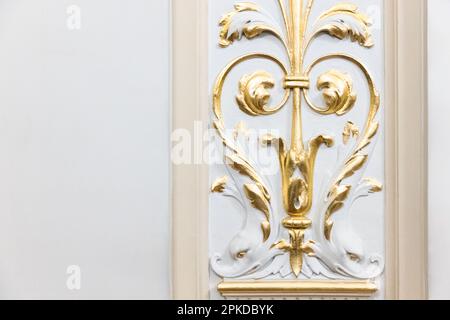 Intérieur de luxe classique, éléments dorés de décoration en gypse sur un mur blanc Banque D'Images