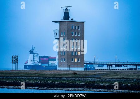 Épais brouillard en hiver, suspendu au-dessus de l'embouchure de l'Elbe dans la mer du Nord, navire-conteneur court dans la tour Elbe Radar de Wasser- und Schifffahrt Banque D'Images