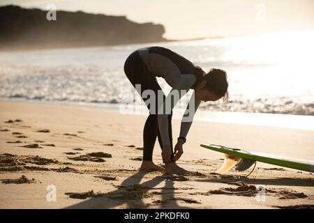 Femme en combinaison se prépare à surfer Banque D'Images