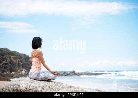 Femme méditant sur la plage Banque D'Images