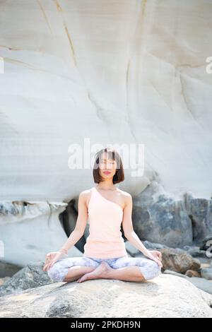 Femme méditant sur la plage Banque D'Images
