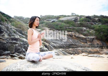 Femme méditant sur la plage Banque D'Images