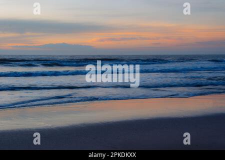 Plage devant un coucher de soleil Banque D'Images