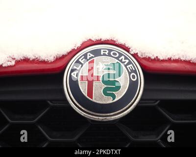 Avant d'une voiture Alfa Romeo, recouverte de neige, montrant l'écusson de la marque. Décembre 2022. Banque D'Images