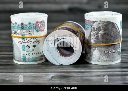 Rouleaux d'Égypte billets de banque d'argent de 100 et 50 EGP LE cent Egyptien et cinquante livres isolés sur le bois caractéristiques Sultan Hassan et Abu Hurayba Banque D'Images