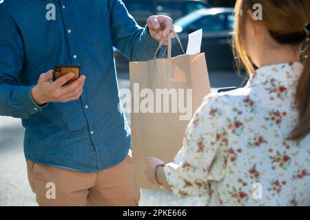 L'homme et la femme se sont livrés à la livraison de nourriture Banque D'Images