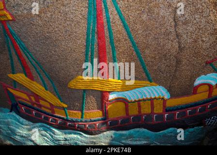 Un lorcha, un navire à trois mâts avec une coque de style européen et les voiles et le gréement d'une jonque chinoise, représenté par un bas-relief coloré sur un rocher de granit avant le temple A-Ma à Macao, en Chine. Il représente le navire d'un pêcheur pauvre qui transportait A-Ma, déesse mère taoïste et protecteur des gens de mer, à la sécurité après une tempête. Le temple, datant de 1488 après J.-C., a été construit là où elle a atterri. Banque D'Images