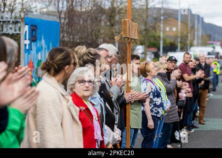 Les gens applaudissent après avoir pris part au culte entre les Gates, une partie du mur de la paix humaine par l'église de la ville de New Life sur Northumberland Street à Belfast, entre la communauté unioniste de Shankill et la communauté nationaliste irlandaise de Falls Road. Date de la photo: Vendredi 6 avril 2023. Banque D'Images