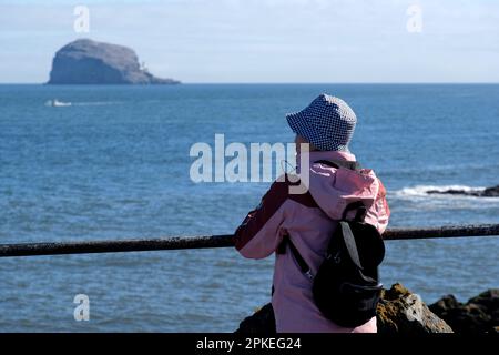 North Berwick, Écosse, Royaume-Uni. 07th avril 2023. Un magnifique départ ensoleillé le matin amène les visiteurs de vacances de Pâques et les habitants sur les plages de Berwick du Nord. Visiteur regardant vers le Bass Rock. Crédit : Craig Brown/Alay Live News Banque D'Images