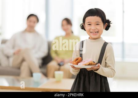 Fille souriant avec des beignets Banque D'Images