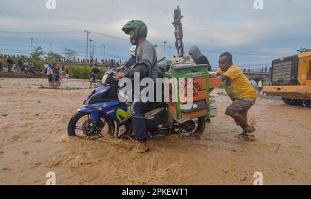 Palu, Indonésie. 07th avril 2023. Un des ponts d'accès reliant les provinces de Sulawesi central et Sulawesi ouest a été coupé, pour être précis dans la ville de Palu, Sulawesi central. Le passage de véhicules à deux et à quatre roues doit utiliser une autre solution en traversant la rivière. Les policiers de la République d'Indonésie ont immédiatement installé une ligne de police sur le pont afin qu'aucun véhicule ne passe et qu'ils n'interdisaient pas aux résidents de passer sur le pont. (Photo de Wahono/Pacific Press) Credit: Pacific Press Media production Corp./Alay Live News Banque D'Images