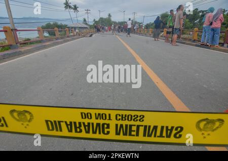 Palu, Indonésie. 07th avril 2023. Un des ponts d'accès reliant les provinces de Sulawesi central et Sulawesi ouest a été coupé, pour être précis dans la ville de Palu, Sulawesi central. Le passage de véhicules à deux et à quatre roues doit utiliser une autre solution en traversant la rivière. Les policiers de la République d'Indonésie ont immédiatement installé une ligne de police sur le pont afin qu'aucun véhicule ne passe et qu'ils n'interdisaient pas aux résidents de passer sur le pont. (Photo de Wahono/Pacific Press) Credit: Pacific Press Media production Corp./Alay Live News Banque D'Images