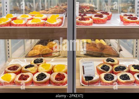 Assortiment de différents types de brioches disposés sur plateau de vente à la boulangerie. Banque D'Images