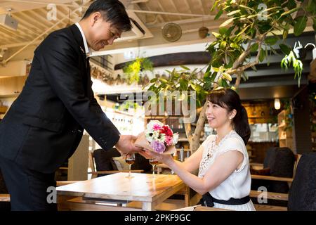 Mari qui remet bouquet à sa femme Banque D'Images