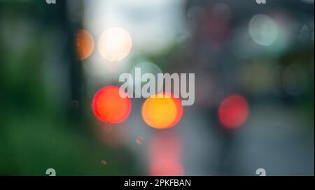 Arrière-plan abstrait défoqué d'une lumière colorée sous la pluie Banque D'Images