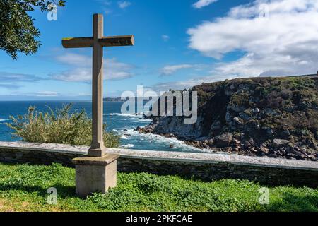Croix de pierre en face des falaises de la mer Cantabrique dans la ville touristique de Luarca, Asturies. Banque D'Images