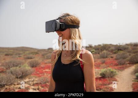 Un randonneur utilise des micro-casques de réalité virtuelle au cours d'une randonnée, concept de mise en œuvre technologique. Banque D'Images