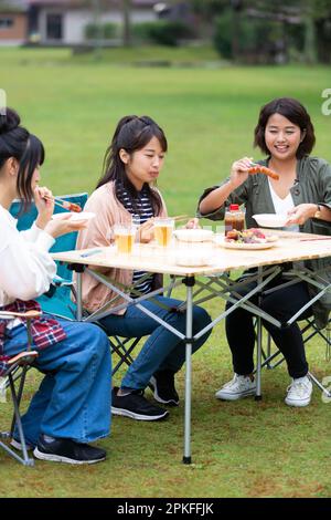 Woman eating at campsite Banque D'Images