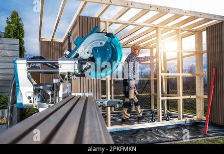 Homme caucasien dans son bâtiment de 40s petit jardin moderne Shed. Bâtiment en bois. Banque D'Images