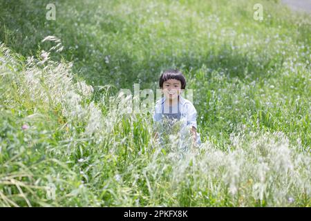 Garçon debout dans l'herbe Banque D'Images