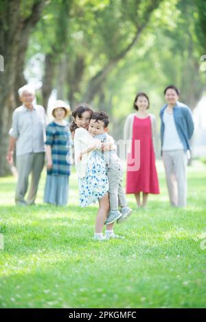Trois générations d'une famille souriant à une rangée de peupliers Banque D'Images