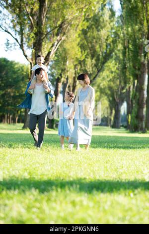 Famille marchant le long des peupliers Banque D'Images