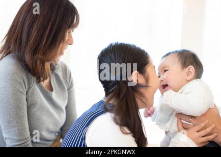 Les sœurs souriant les unes aux autres et la mère regardant Banque D'Images