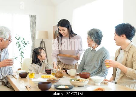 Une famille de trois personnes prenant le petit déjeuner Banque D'Images
