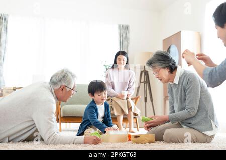 Grands-parents et petits-enfants jouant avec des jouets Banque D'Images