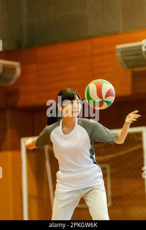 Une étudiante jouant au volley-ball dans un gymnase Banque D'Images