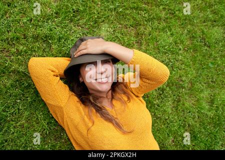 Smiling woman lying on the grass Banque D'Images