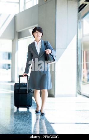 Une Businesswoman pulling suitcase Banque D'Images