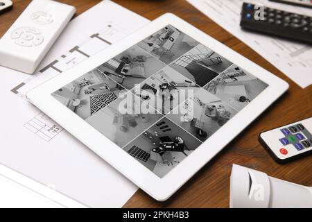 Tablette avec vue des caméras de vidéosurveillance sur une table en bois, gros plan. Système de sécurité domestique Banque D'Images