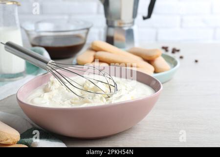 Bol avec crème mascarpone sur table en bois blanc. Préparer un gâteau au tiramisu Banque D'Images