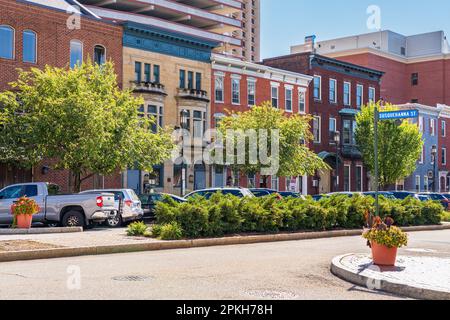 Harrisburg, PA - 26 septembre 2021 : bâtiments modernes de haute élévation vus derrière les maisons traditionnelles en rangée de briques le long de la rue d'Etat à Harrisburg, la tête Banque D'Images