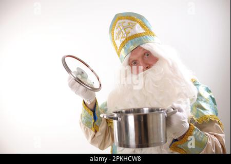 Le Père Noël tenant une casserole prêt à servir ou à être livré à emporter avec soin. Préparation culinaire festive. Bonne année. Photo de haute qualité Banque D'Images