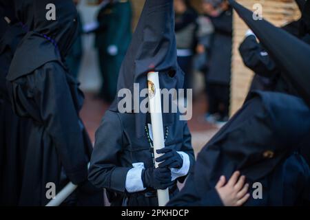 Sahagun, Espagne. 07th avril 2023. Un jeune pénitent joue avec une bougie LED, lors de la procession du Saint-Burial qui a visité les rues de Sahagun. Crédit : SOPA Images Limited/Alamy Live News Banque D'Images