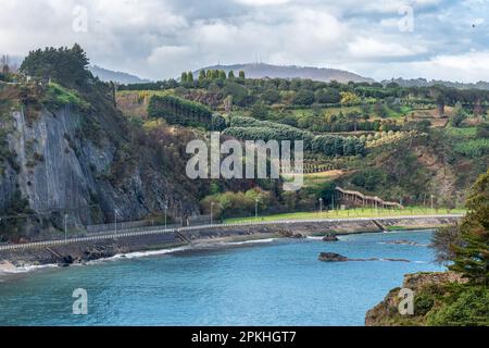 Paysage montagneux vert au bord de la mer avec promenade dans la ville asturienne de Luarca, Espagne. Banque D'Images