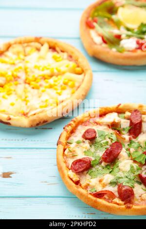 Trois différentes sortes de pizzas sur une table en bois bleu. Aller à la verticale. Vue de dessus Banque D'Images