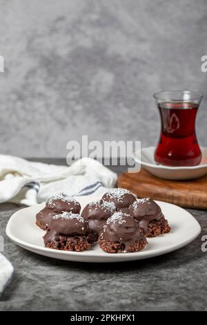 Biscuits aux noix de coco et aux pépites de chocolat. Produits de boulangerie. Biscuits avec thé sur fond sombre Banque D'Images