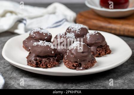 Biscuits aux noix de coco et aux pépites de chocolat. Produits de boulangerie. Biscuits avec thé sur fond sombre. Gros plan Banque D'Images