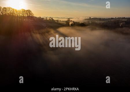 Le soleil levant projette des ombres dans la brume de la vallée de la Frome autour de Farleigh Hungerford, près de Bath. Date de la photo: Samedi 8 avril 2023. Banque D'Images