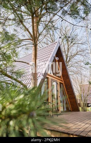 Chalet en bois à cadre en a avec un pin flou en premier plan Banque D'Images