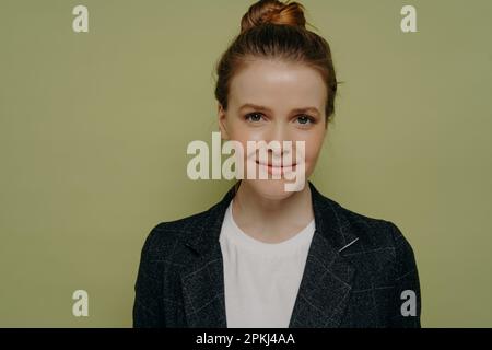 Gros plan de jeune fille jeune fille souriante tendance étudiante vêtue de vêtements décontractés posant en studio, jolie fille adolescente heureuse regardant l'appareil photo avec un léger sourire Banque D'Images