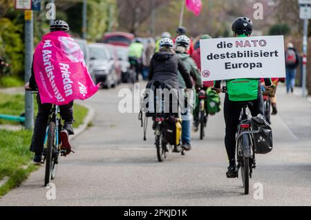 Stuttgart, Allemagne. 08th avril 2023. Un participant à un rassemblement de paix fait des cycles avec un panneau indiquant « l'OTAN déstabilise l'Europe » depuis la porte principale de l'EUCOM à la caserne de patchs de Vaihingen en direction du centre-ville de Stuttgart. En 2023 également, de nombreuses marches de Pâques ont eu lieu à travers l'Allemagne sous l'impression de la guerre de la Russie contre l'Ukraine. Credit: Christoph Schmidt/dpa/Alay Live News Banque D'Images