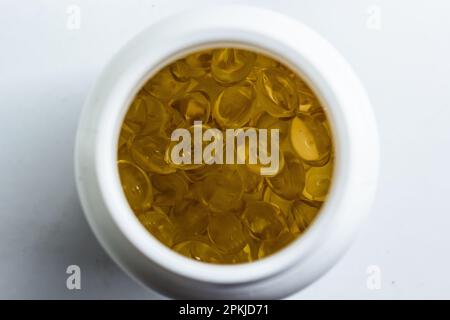 beaucoup de capsules de gélatine jaune sur fond clair. vitamines omega, gros plan, macro. Banque D'Images