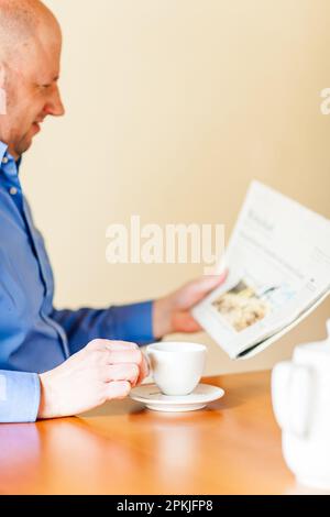 A Best Ager est de boire du café et de lire un journal. Banque D'Images