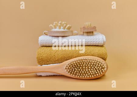 Brosses et serviettes de massage en bambou naturel pour le massage au spa. Brosse massante à poils naturels sur une serviette en éponge. Concept de SPA à domicile, soins personnels. Banque D'Images