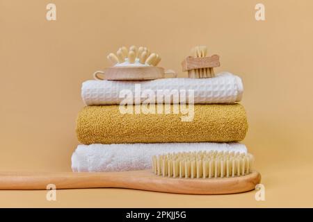 Brosses et serviettes de massage en bambou naturel pour le massage au spa. Brosse massante à poils naturels sur une serviette en éponge. Concept de SPA à domicile, soins personnels. Banque D'Images