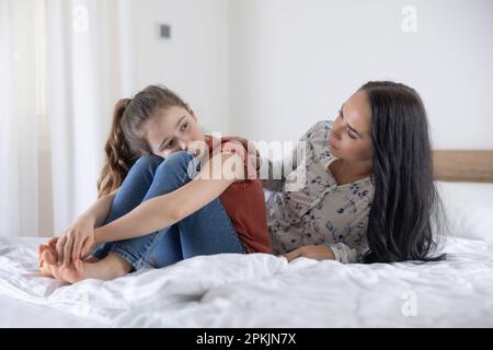 La femme adulte tente de communiquer avec une jeune fille dépressive et triste à la maison. Banque D'Images